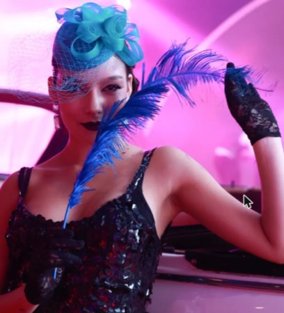 Performer con tocado turquesa y pluma azul