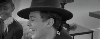 Modelo con sombrero fedora riendo, en blanco y negro