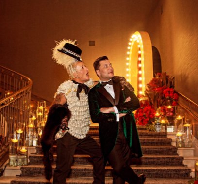 Dos performers con chistera y plumas en la escalera